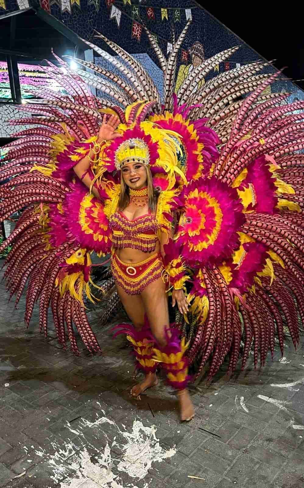 DanÃ§arina com fantasia exuberante de penas rosas e amarelas