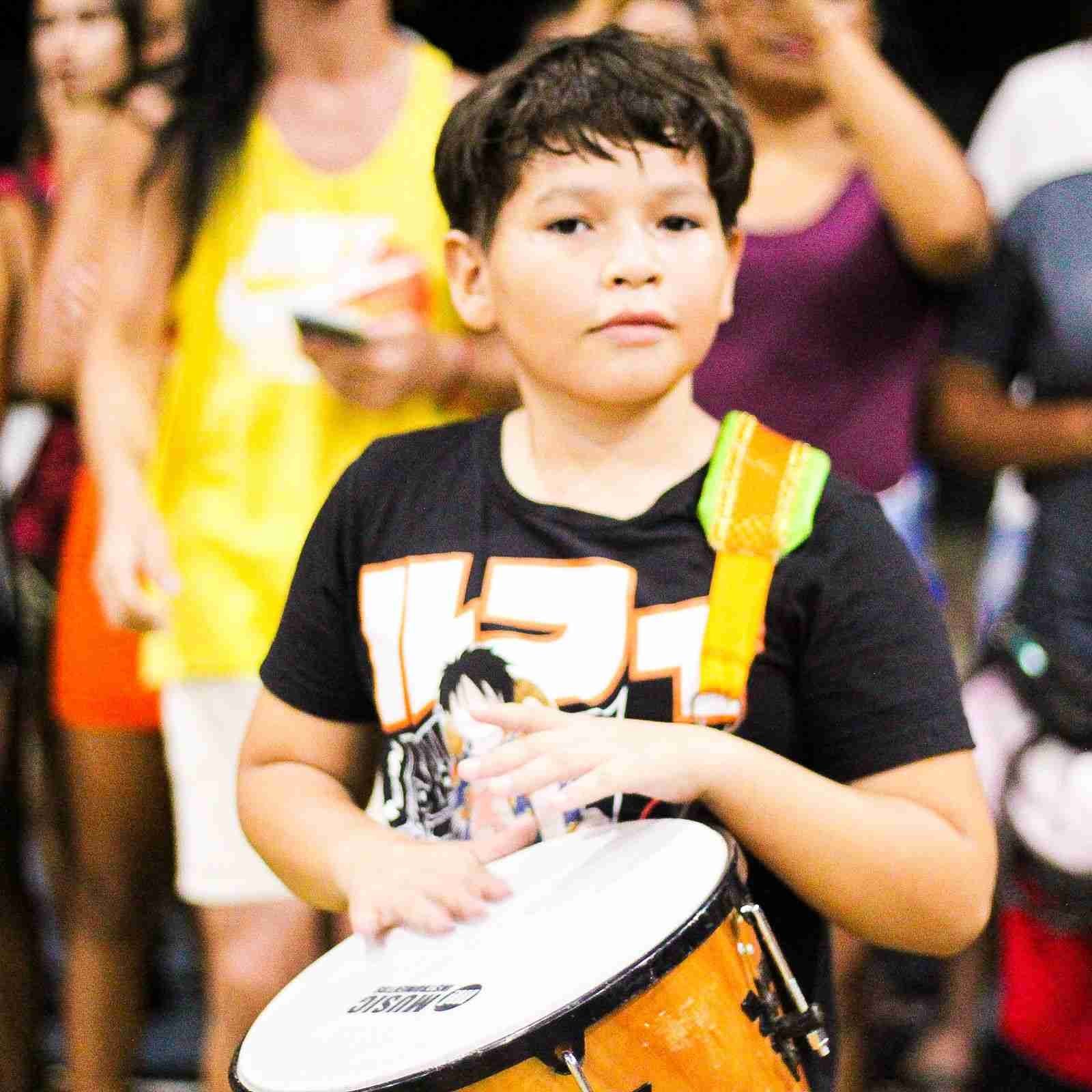 CrianÃ§a tocando tambor durante o desfile